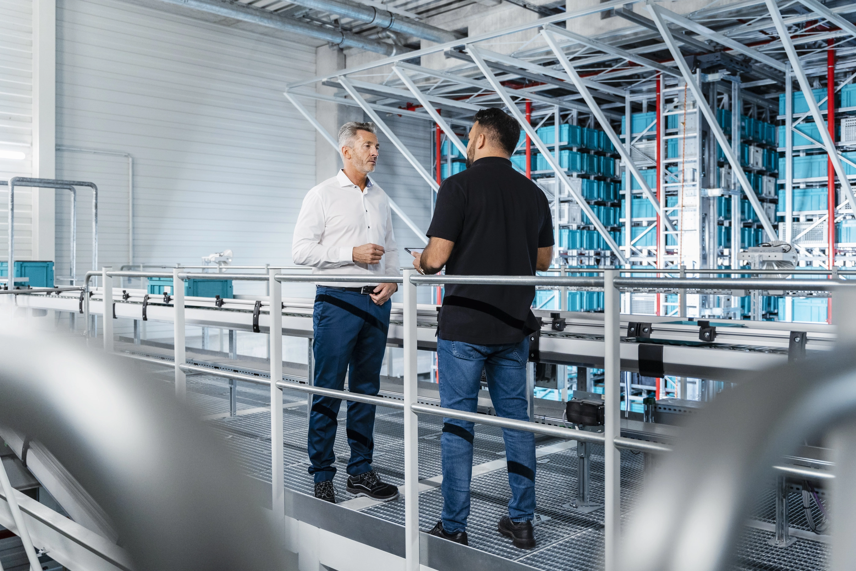 Businessman discussing with manager at warehouse railing